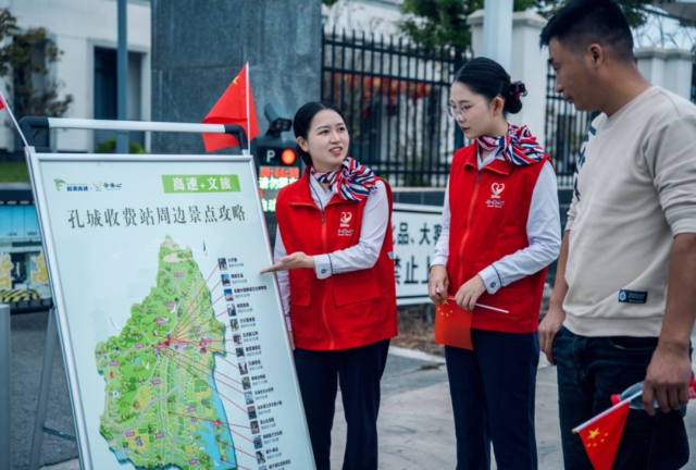 合安中心孔城站文旅推介員向前來咨詢司乘人員贈送小國旗.png